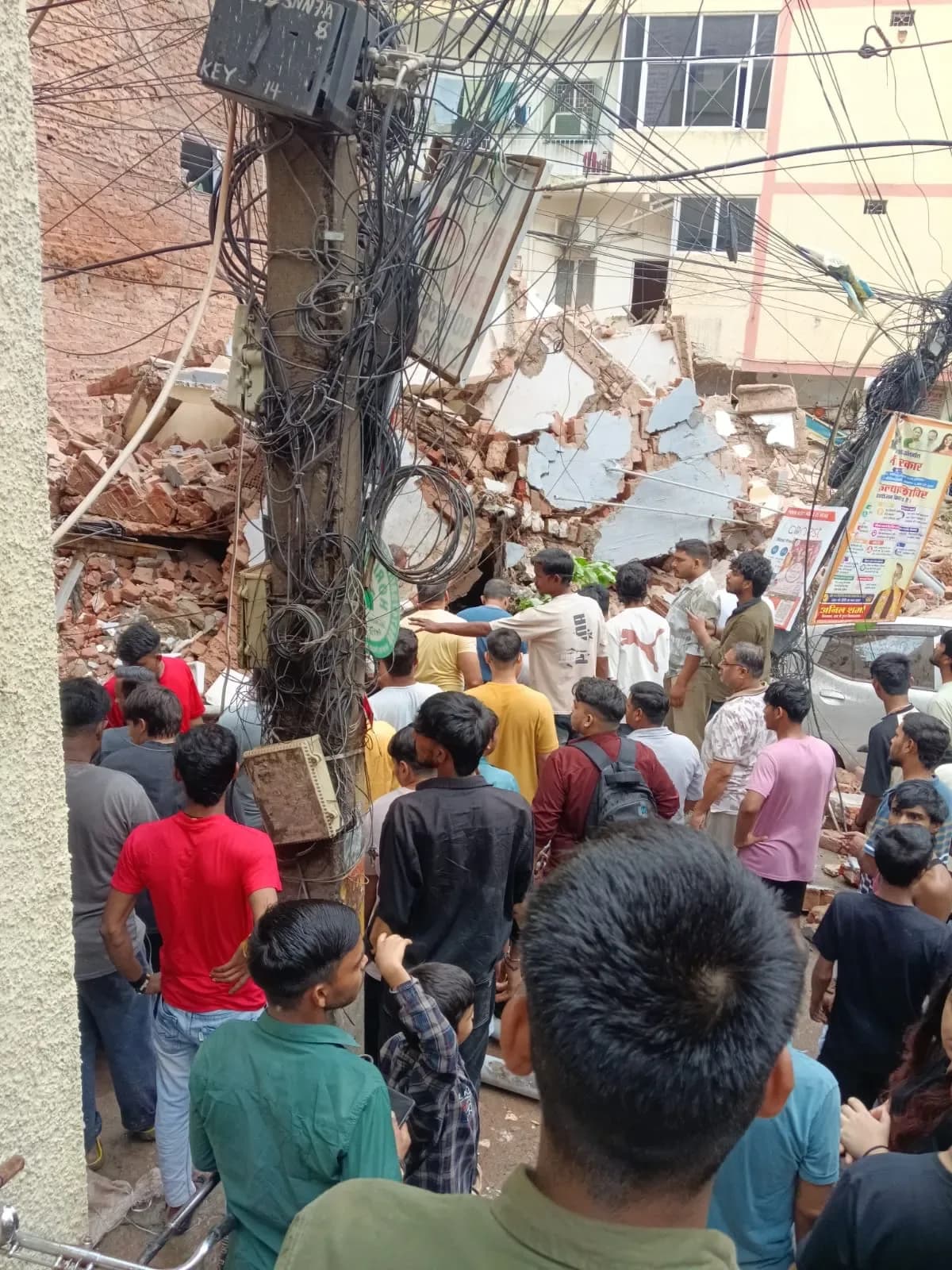 Rescue workers and crowds gathered around the completely collapsed Daze PG building in Delhi's Satya Niketan area.